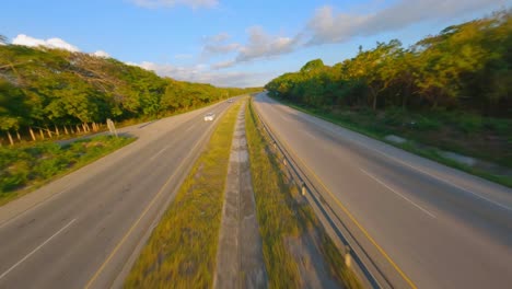 Automóviles-Circulando-Por-Autovia-Del-Este,-Autovía-Al-Anochecer-Entre-Bosques-En-República-Dominicana