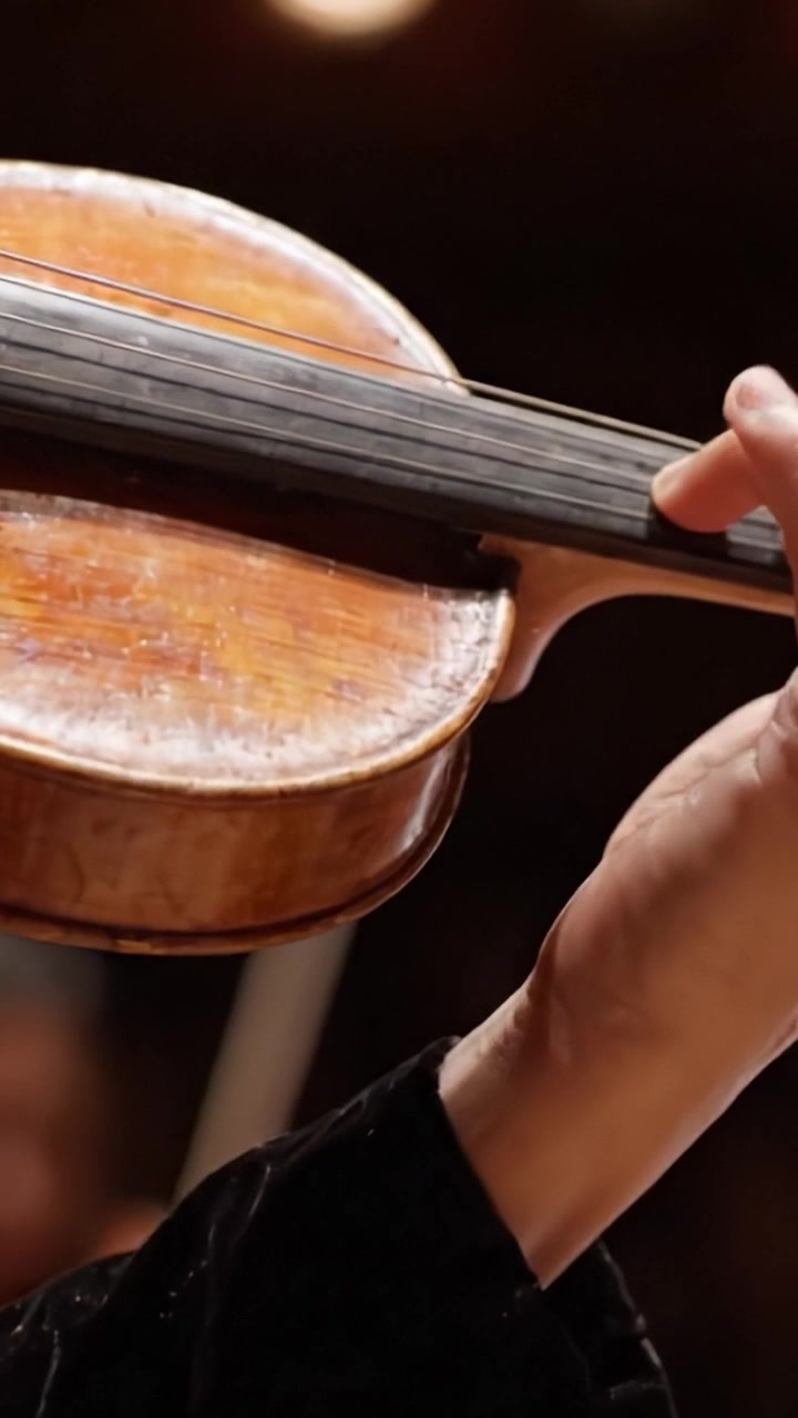 Un'Esplorazione Ravvicinata di una Splendida Viola nelle Mani di un Musicista, Catturando le Complessità dell'Artigianato e l'Emozione in Ogni Archetto