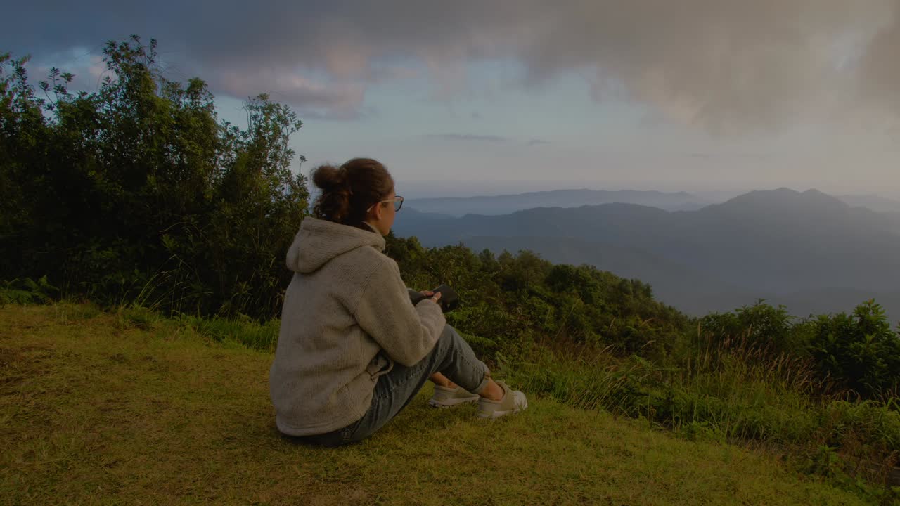 Woman enjoying a mountain view at sunset