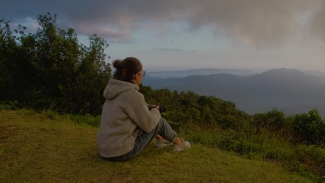 woman enjoying a mountain view at sunset