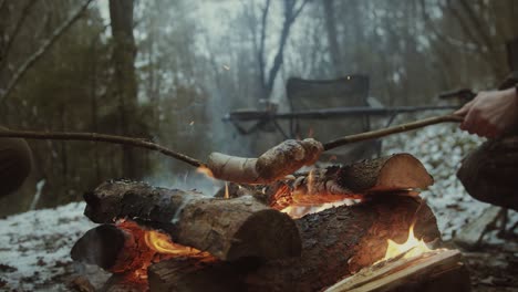 Campistas-Y-Cazadores-Alrededor-De-Una-Fogata-Cocinando-Salchichas,-Asando-Carne-Durante-El-Campamento-De-Invierno