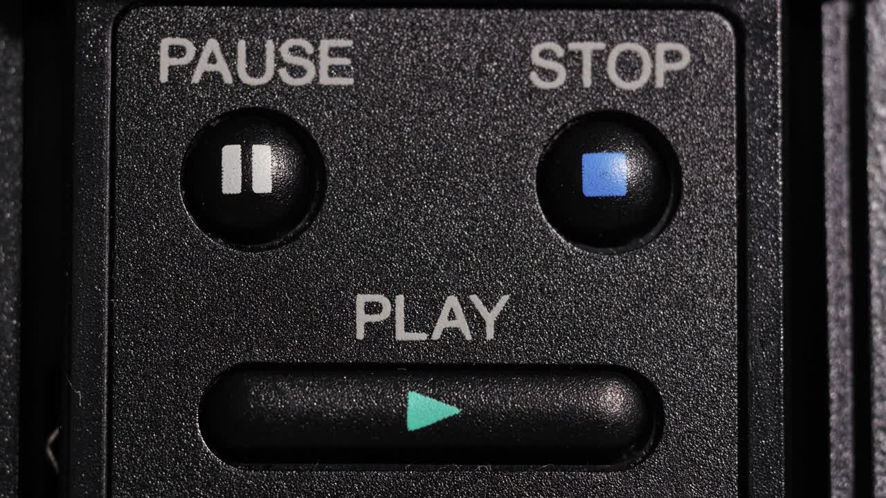 Close up of play button pressed with pause and stop controls visible