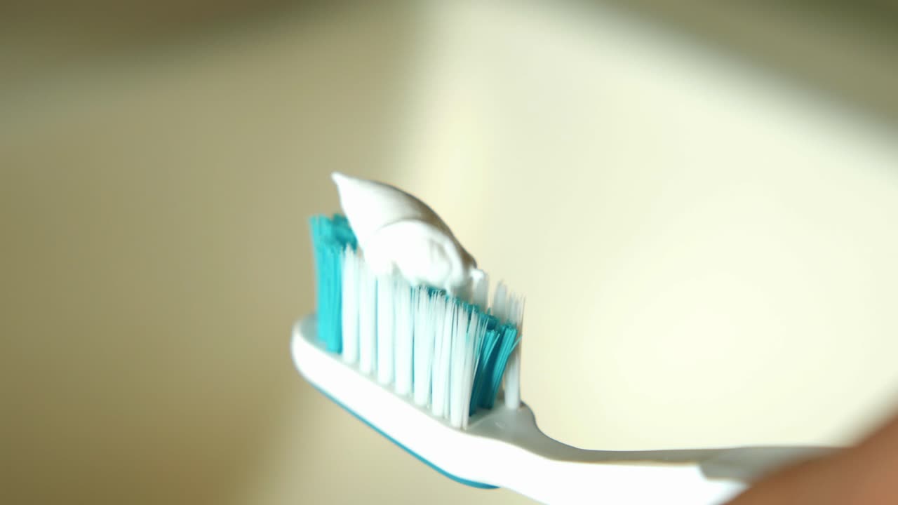 la aplicación de pasta de dientes a un cepillo de dientes