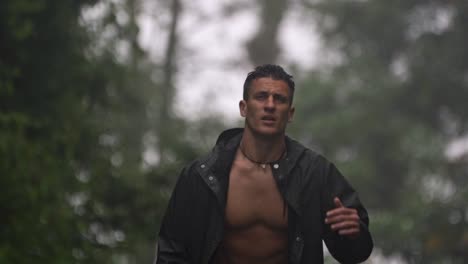 man walking in a foggy, rainy environment, with his jacket unbuttoned in the mountains of alajuela, costa rica, capturing a moment of raw connection with the wild nature