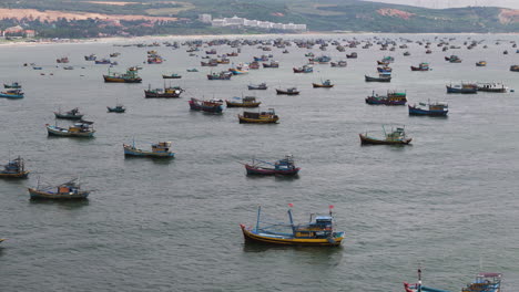 Vuelo-Aéreo-En-Círculos-Sobre-Una-Gran-Cantidad-De-Barcos-Pesqueros-Frente-A-La-Costa-De-Mui-Ne,-Vietnam