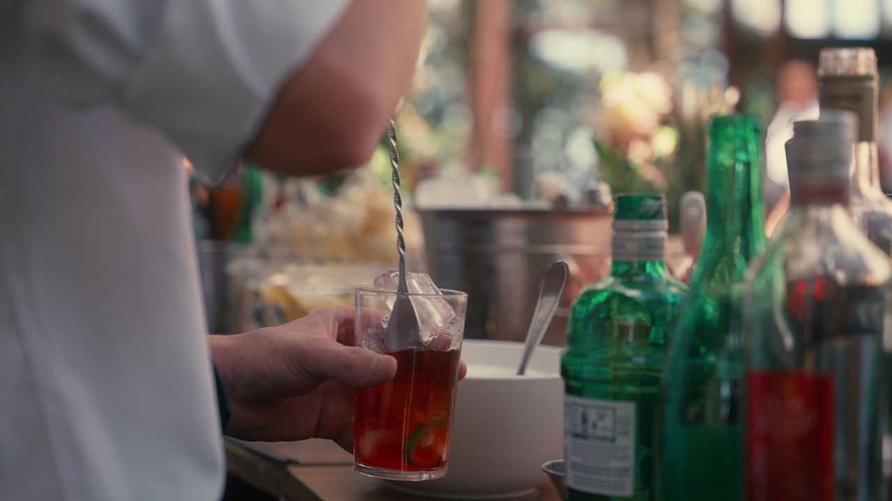 Bartender mixes red drink, negroni