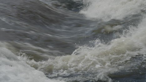 icy water raging from waterfall in quebec canada - close up shot