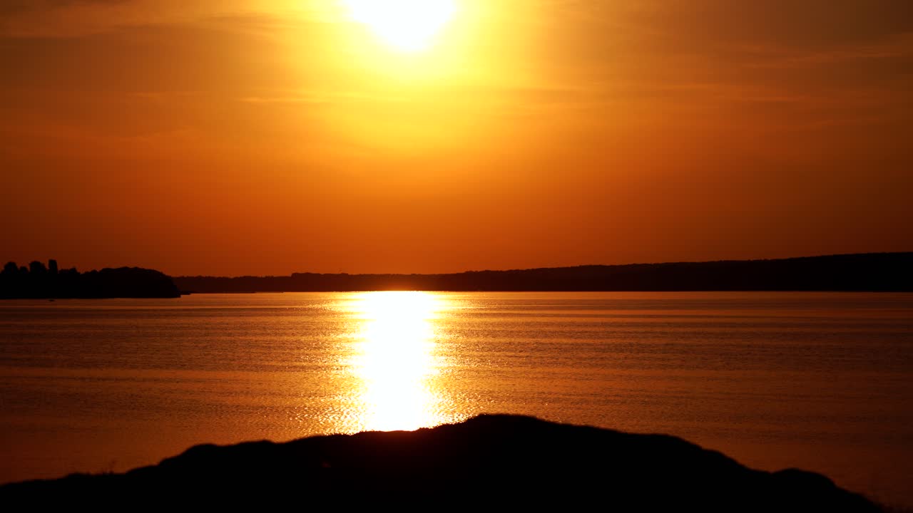 Biker riding on bicycle on hill. Cyclist with mountain bike on rocky trail at sunset
