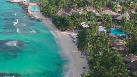 aerial shot of bayahibe beach at sunny morning, where people enjoys vacation on clear caribbean sea shore in dominican republic