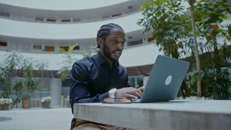man working on a laptop in an outdoor patio