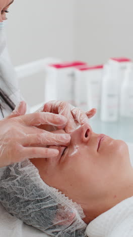 terapeuta de cosmetología haciendo mujer relajante spa masaje facial con las manos en el salón de desintoxicación y curación