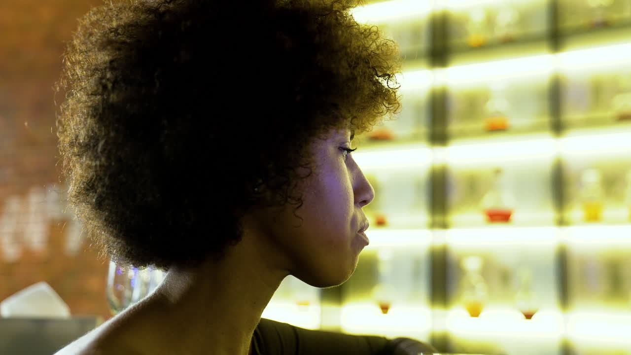 Una mujer bebiendo un cóctel.