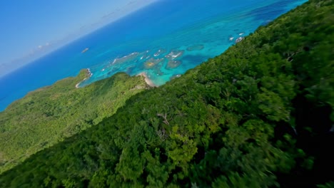 drone flying over tropical forest and descending towards playa ermitano beach, samana in dominican republic