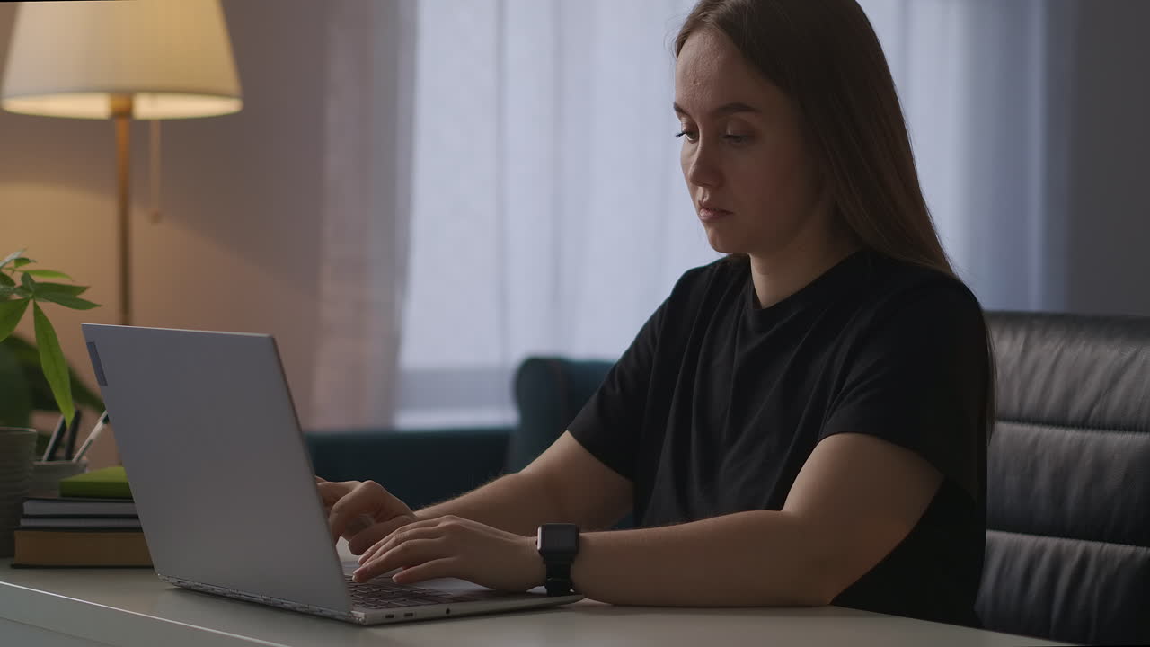 tired woman is closing cover of laptop and touching her head feeling pain and fatigue after long work with computer overworking and tiredness