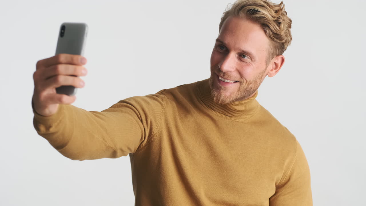 hombre sonriente tomando una foto selfie y posando