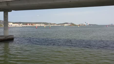 beautiful flight over the water under the bridge and towards the marina and the town of olbia in sardinia