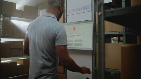 trabajador del almacén escaneando paquetes utilizando una pantalla táctil
