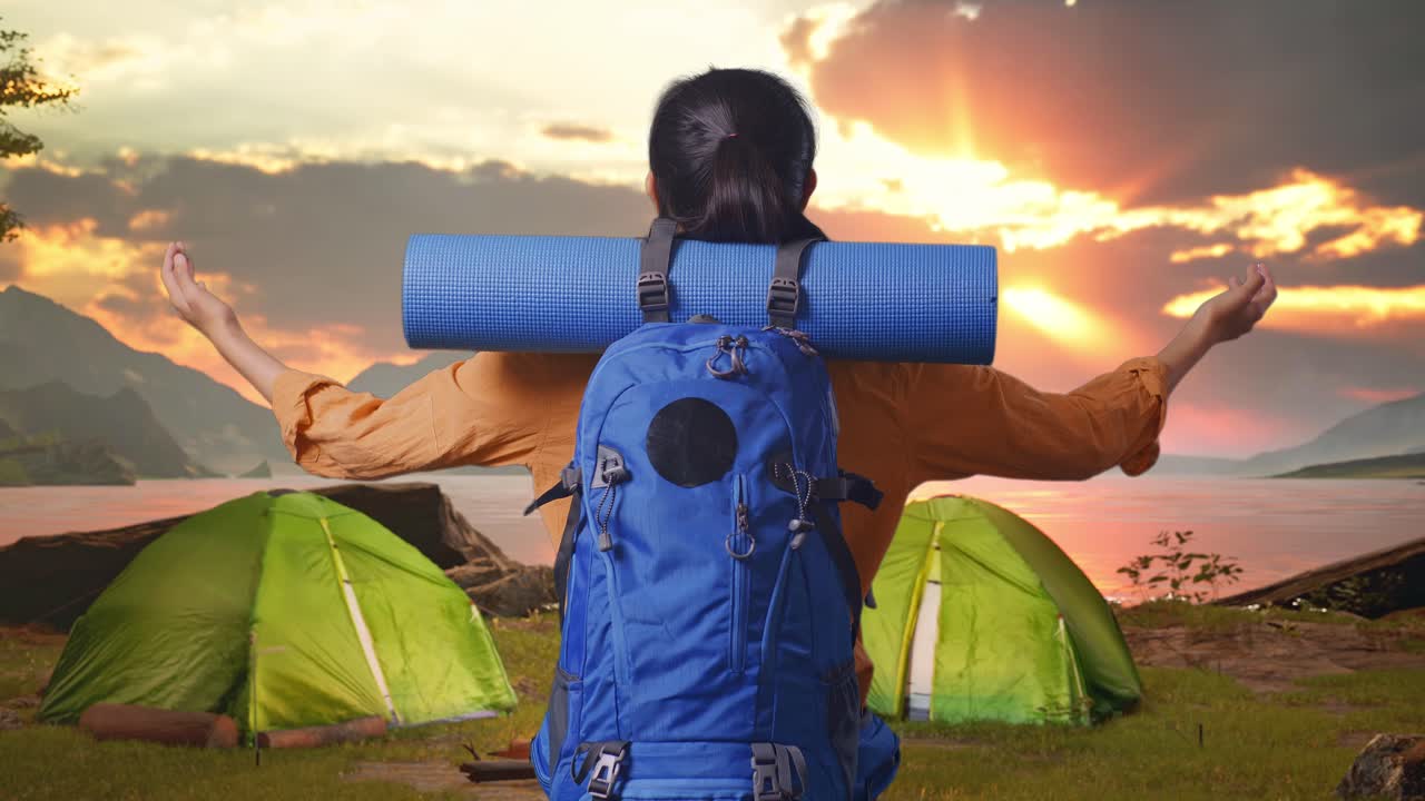 Woman enjoying a serene camping sunrise