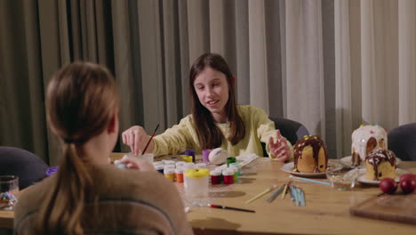 niños pintando huevos de pascua y decorando golosinas