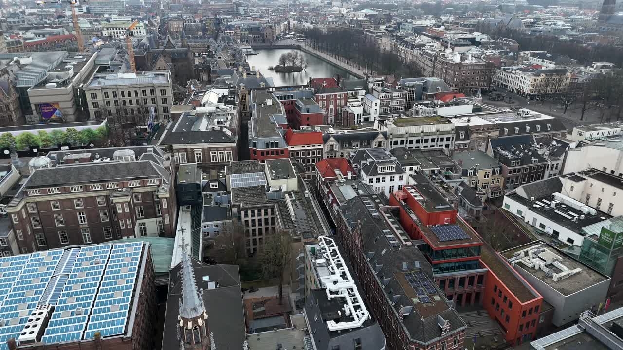 Houses and homes in The Hague with solar panel on roof. Court Pond and Binnenhof architecture in dutch city. Cloudy day in winter season. Aerial forward wide shot.