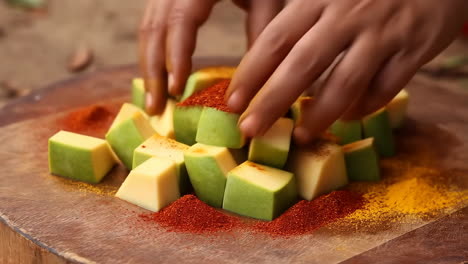adding spices to diced mango for preparation