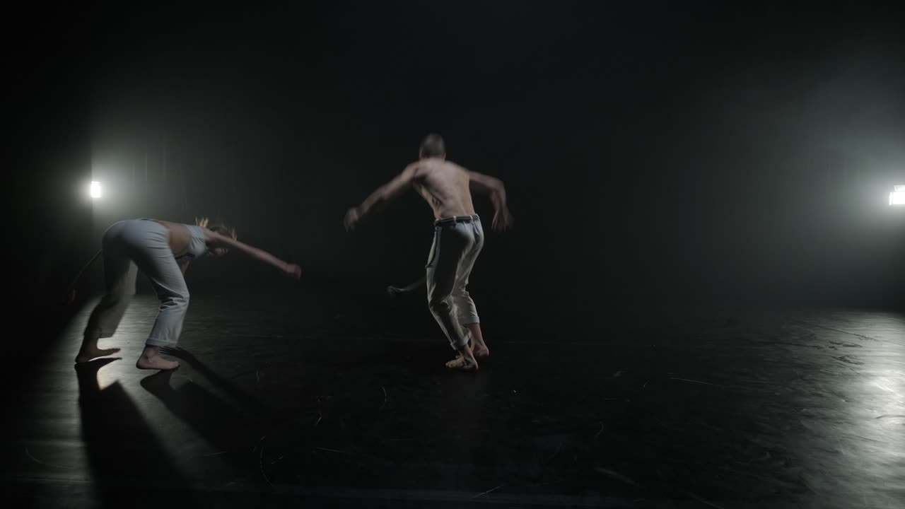 luchadores de capoeira realizando movimientos dinámicos en el escenario. artes marciales, danza y acrobacias en acción. atletas de pecho desnudo mostrando fuerza, flexibilidad y técnica bajo los reflectores