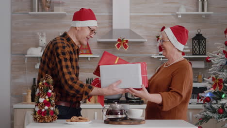 Grandmother-sharing-wrapper-gift-present-with-ribbon-on-it-with-grandfather