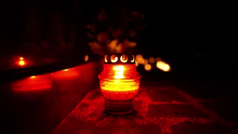 candles burning at night in a cemetery