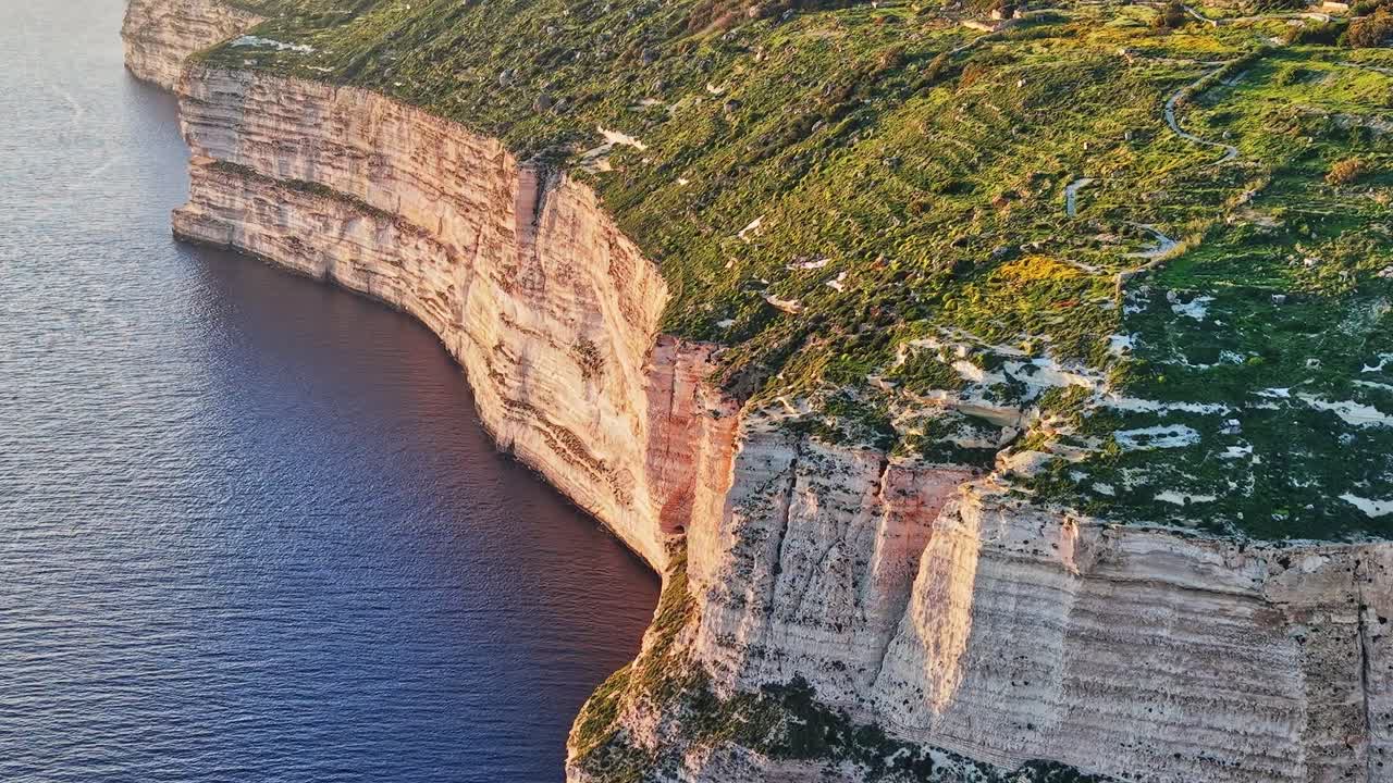 Rocky coastline of Malta near the blue water and green land