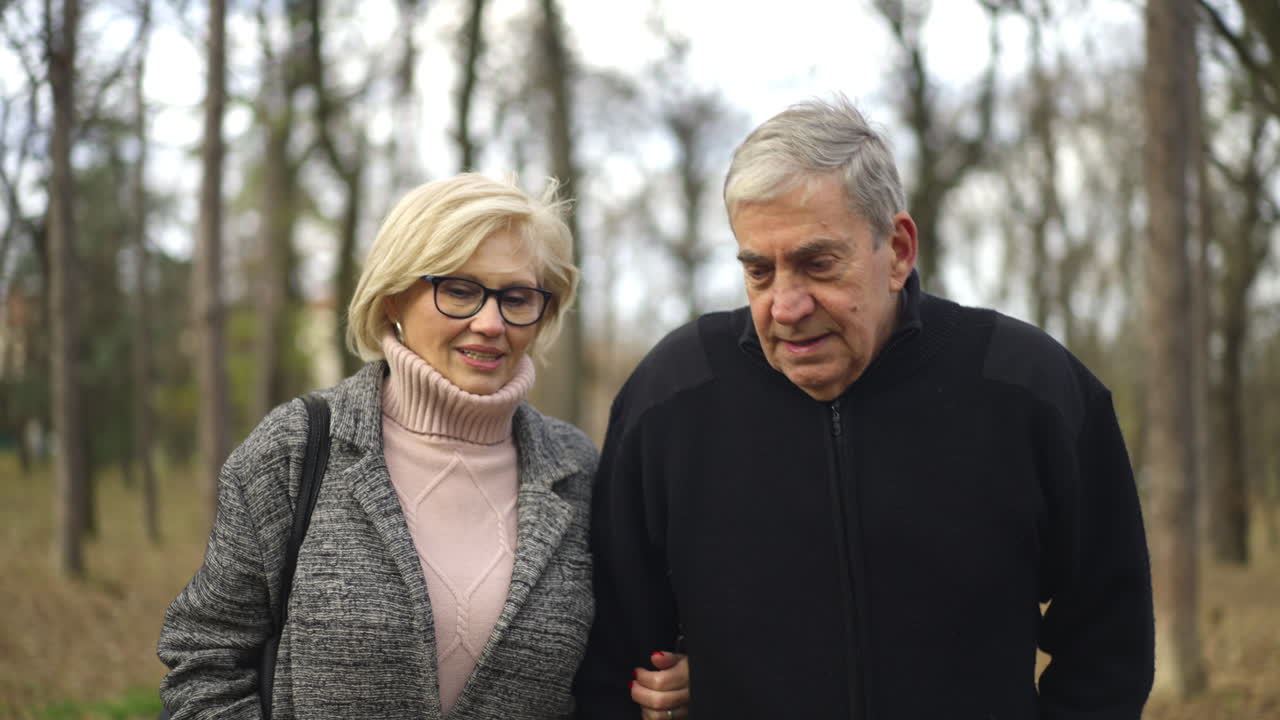 Una pareja de mayores caminando por el parque.