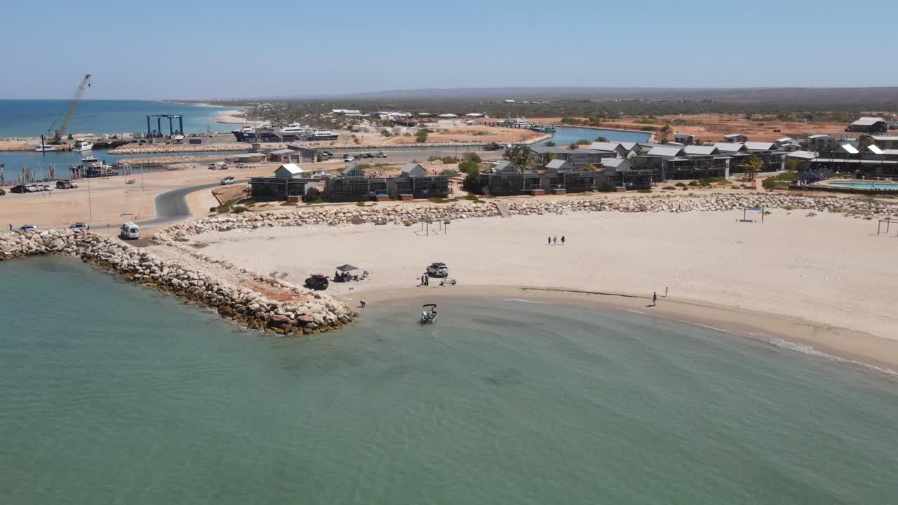 4k 작은 보트가 청록색 바다의 모래 해변 해안에 상륙합니다.