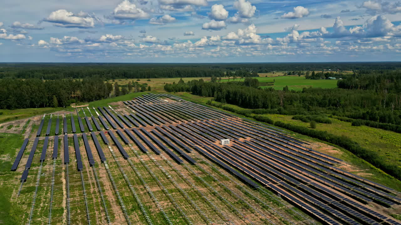 Orbit hyperlapse above solar farm construction captured from above, with rows of solar panels and surrounding landscape