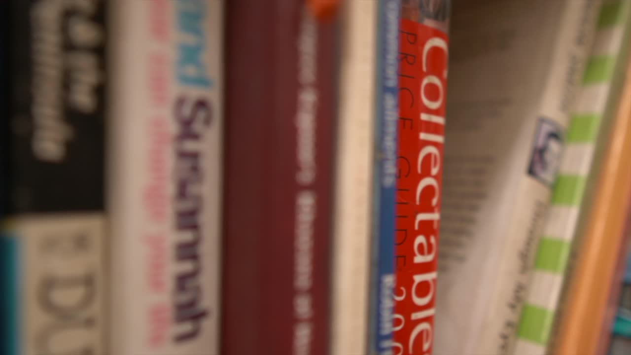 Tracking shot of different book stacks in a library, close-up