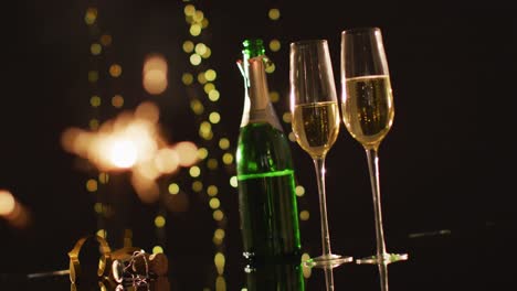 champagne glasses and decorations on black background at new year's eve