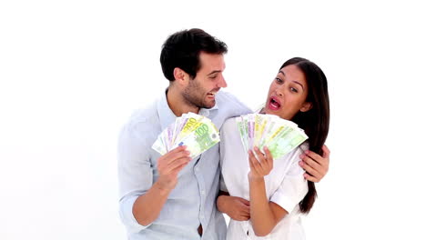 una pareja joven y atractiva mostrando su dinero.