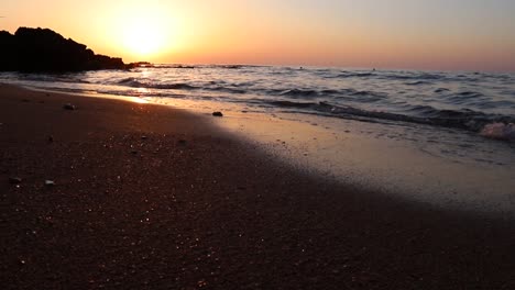 calm ocean sea water waves breaking on sandy beach at sunset, tyre, lebanon, static low angle