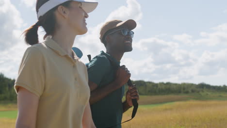 caucasian woman and african american man on the golf course.