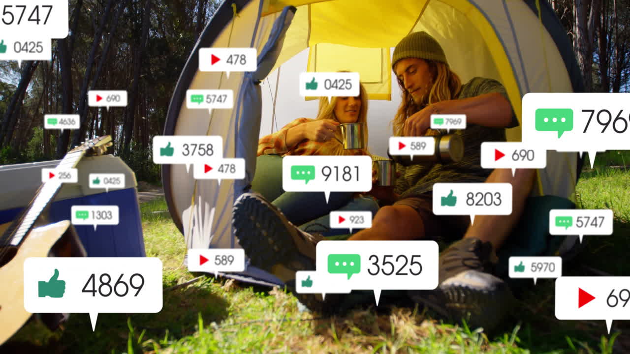 man and woman sitting inside yellow camping tent, holding mugs, showing floating social media icons
