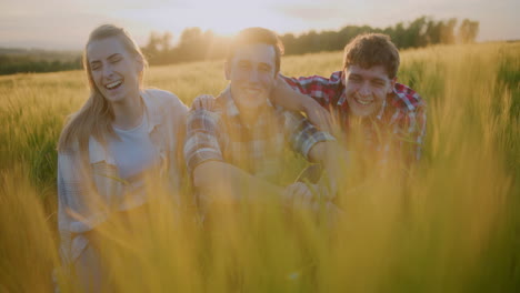 three happy friends against golden sunset background