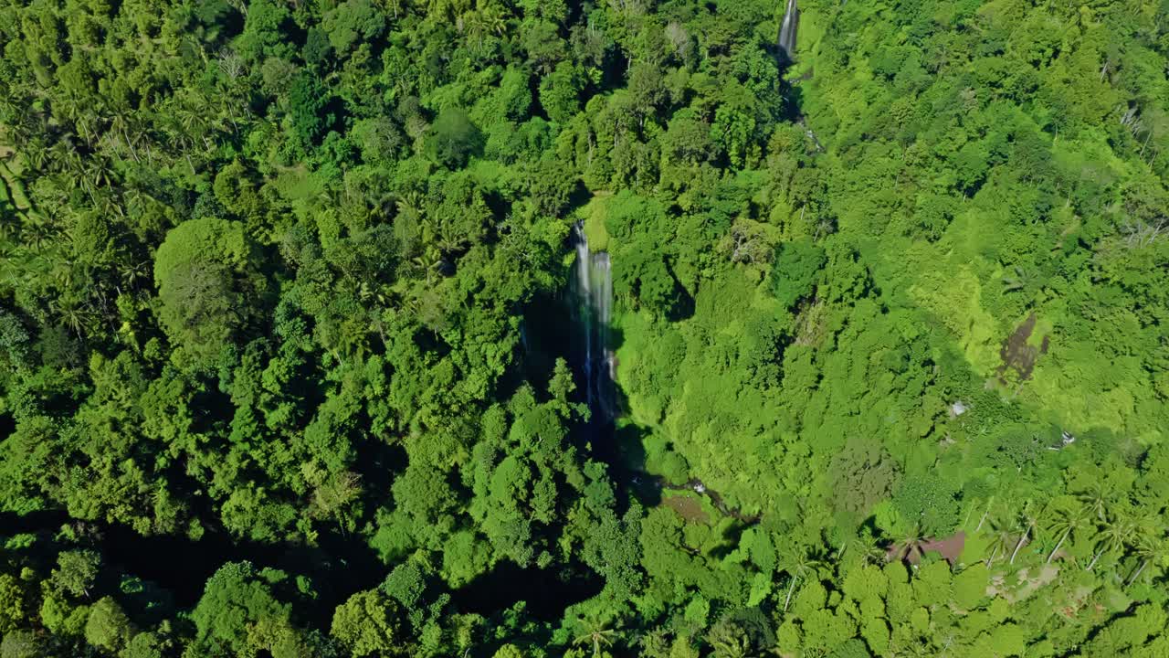 Wide high angled aerial cinematic footage of two waterfalls in the midst of dense jungle environment