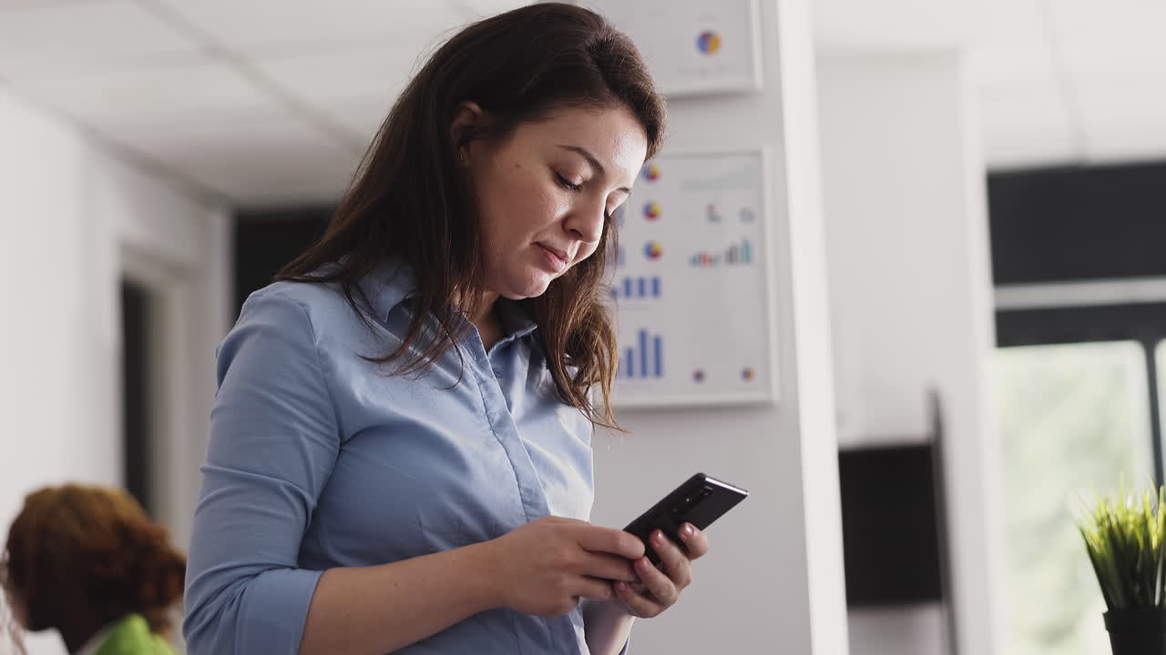 mujer de negocios usando teléfono inteligente en la oficina