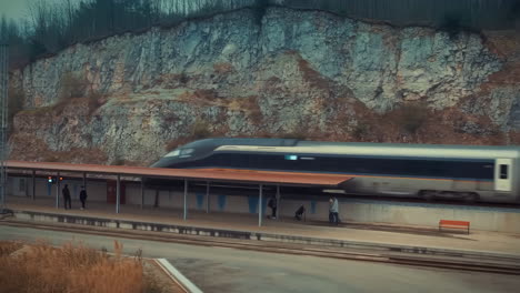 high-speed train passing a station platform