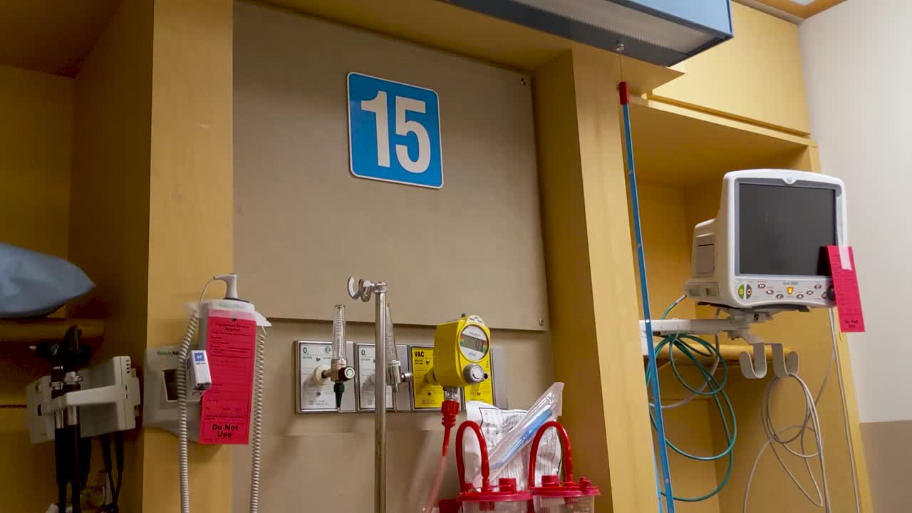 Lenta panoramica verso il basso di apparecchiature mediche sulla parete di fondo di un pronto soccorso.