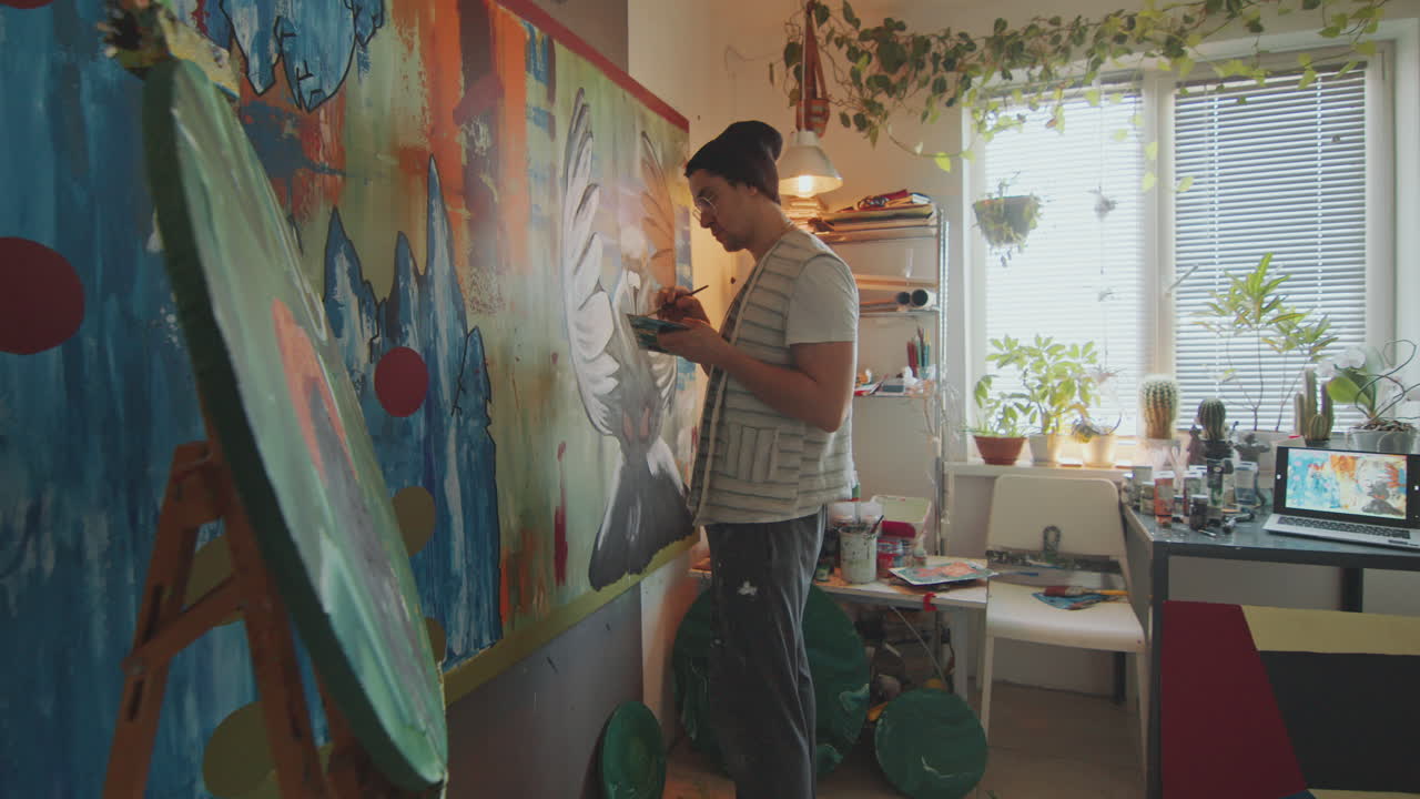 Artista pintando una gran obra de arte abstracto en un acogedor estudio creativo