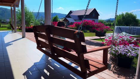 a peaceful afternoon on a wooden swing surrounded by vibrant flowers and scenic landscape, inviting relaxation in nature's embrace