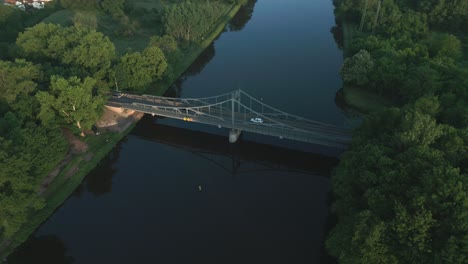 Coches-Cruzando-El-Río-Sobre-Un-Puente-De-Acero-De-Principios-Del-Siglo-XX