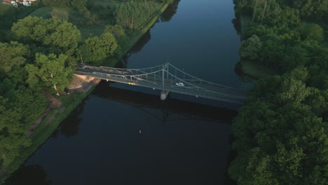 cars crossing the river over a steel bridge from the early 20th century