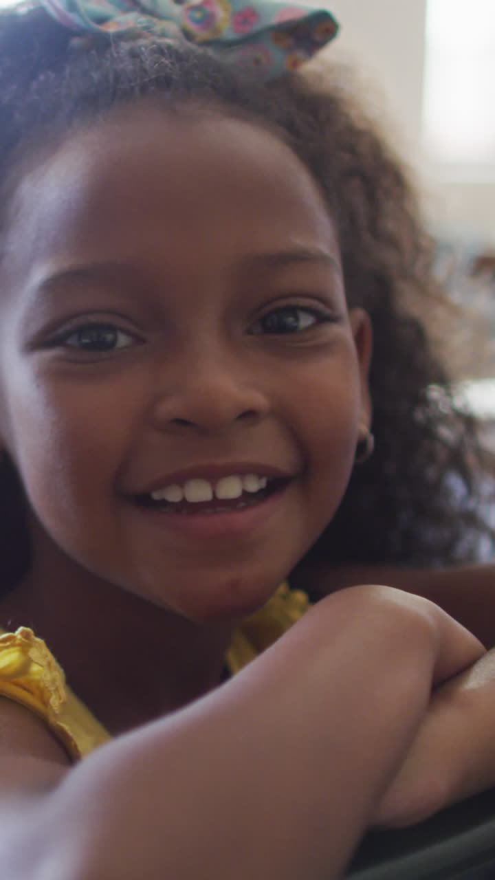 видео счастливой афроамериканской девушки-инвалида, сидящей за столом в классе.