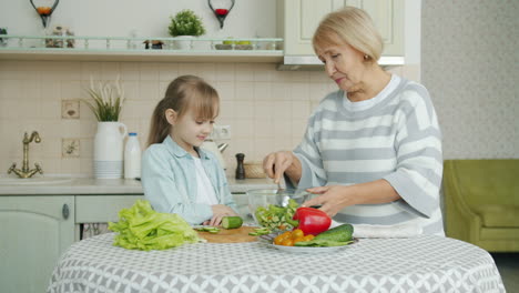 grandmother and granddaughter making salad