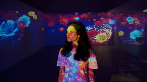 woman in an immersive floral light projection art exhibition